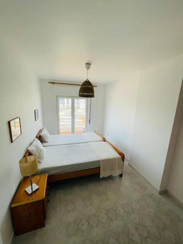 Two beds bedside table and lamp bedroom at Sunny flat very close to the beach in Faro Student Accommodation