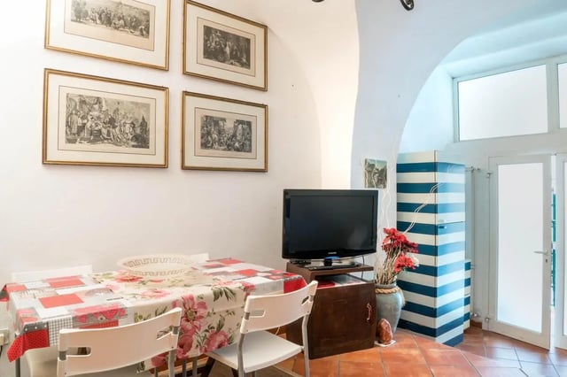 Framed art table TV striped cabinet dining area at Cosy double-bedroom apartment in Albenga (SV) in Albenga Student Accommodation