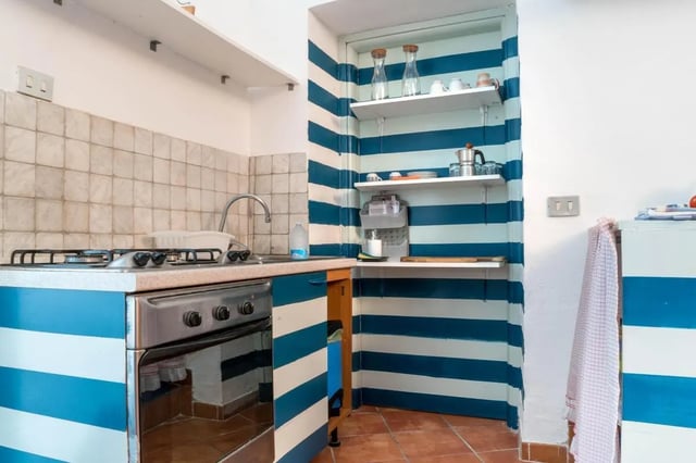 Striped cabinets stove sink shelves kitchen at Cosy double-bedroom apartment in Albenga (SV) in Albenga Student Accommodation