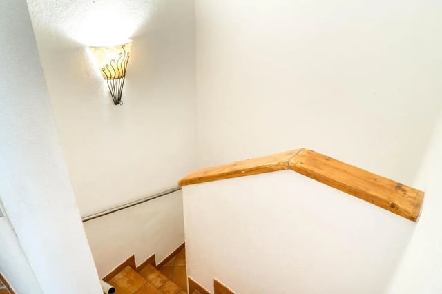 Stairs with wooden railing and wall sconce stair area at Cosy double-bedroom apartment in Albenga (SV) in Albenga Student Accommodation