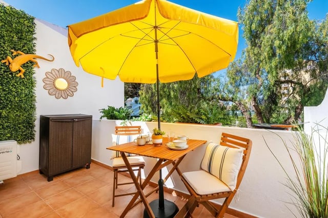 Table chairs umbrella and storage cabinet balcony exterior at Luxurious 1-bedroom apartment in Vilamoura in Faro Student Accommodation