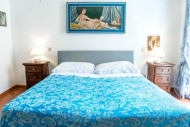 Bed nightstands lamps painting bedroom at Cosy double-bedroom apartment in Albenga (SV) in Albenga Student Accommodation