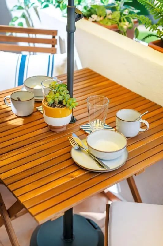 Table with place setting and plants balcony area at Luxurious 1-bedroom apartment in Vilamoura in Faro Student Accommodation