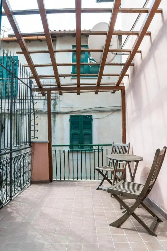 Wooden table chairs and satellite dish balcony exterior at Cosy double-bedroom apartment in Albenga (SV) in Albenga Student Accommodation