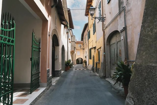 Street with old buildings and green gates Exterior at Cosy double-bedroom apartment in Albenga (SV) in Albenga Student Accommodation