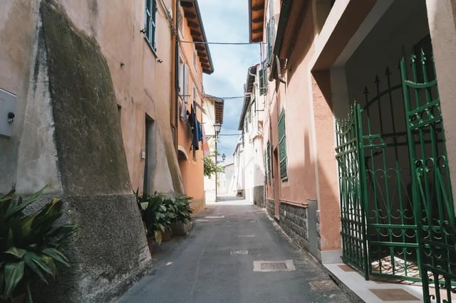 Narrow street with buildings plants exterior at Cosy double-bedroom apartment in Albenga (SV) in Albenga Student Accommodation