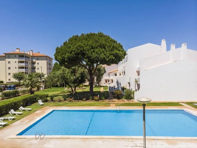 Blue swimming pool with lounge chairs exterior at Luxurious 1-bedroom apartment in Vilamoura in Faro Student Accommodation