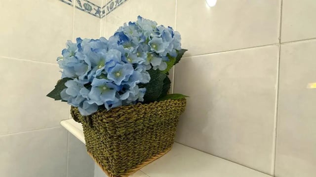 Blue hydrangeas in basket on shelf bathroom at Tasteful 1-bedroom apartment in Albenga in Albenga Student Accommodation