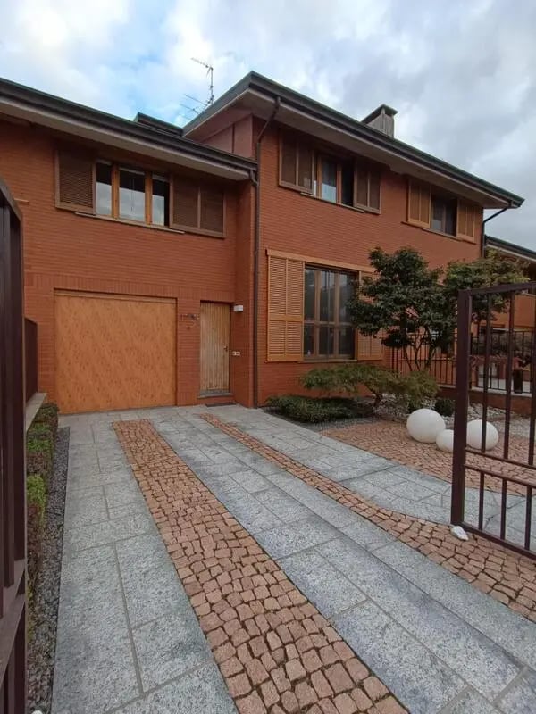 Red brick house with garage and driveway exterior at Comfy studio inside an indipendent house well connected to Università di Novara in Novara Student Accommodation