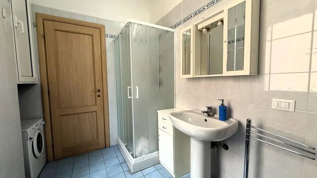 Shower sink medicine cabinet washing machine bathroom at Tasteful 1-bedroom apartment in Albenga in Albenga Student Accommodation