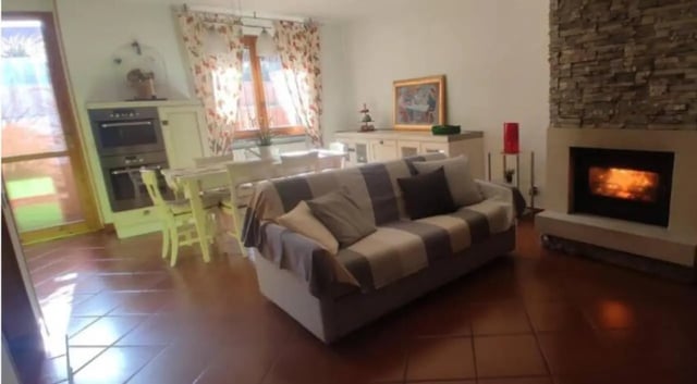 Sofa fireplace and dining table living room at Comfy studio inside an indipendent house well connected to Università di Novara in Novara Student Accommodation