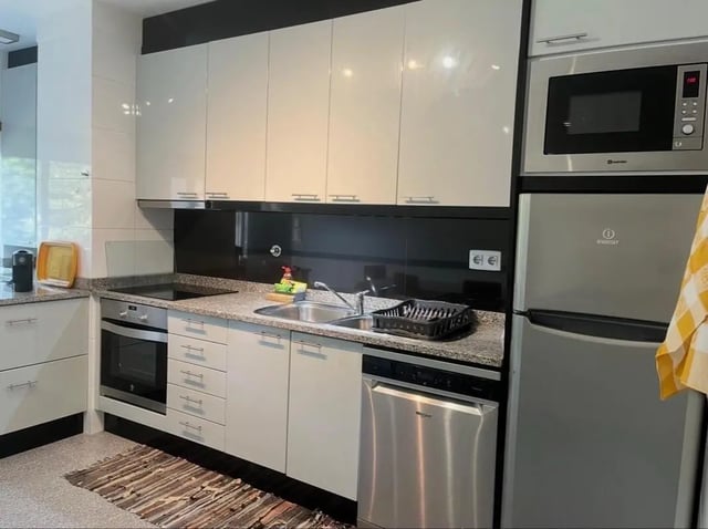 Modern kitchen with oven microwave and refrigerator kitchen at Exclusive 2 Bedroom Apartment with a balcony close to Minho University in Guimaraes Student Accommodation