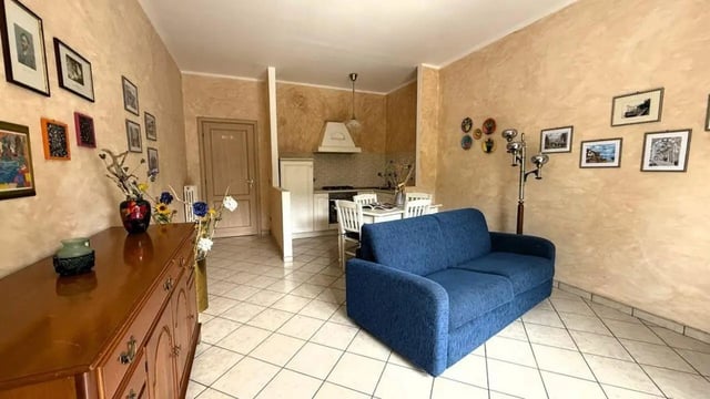 Blue sofa kitchen dining area and dresser living room at Tasteful 1-bedroom apartment in Albenga in Albenga Student Accommodation