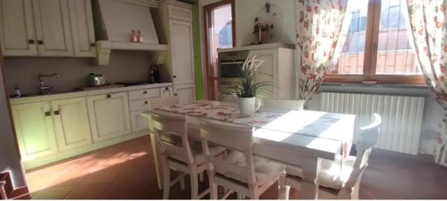 White kitchen cabinets sink stove and dining table kitchen at Comfy studio inside an indipendent house well connected to Università di Novara in Novara Student Accommodation