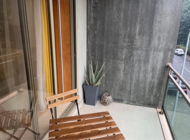 Balcony with wooden table chairs and plant balcony at Exclusive 2 Bedroom Apartment with a balcony close to Minho University in Guimaraes Student Accommodation