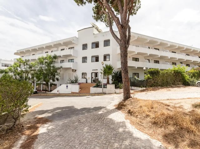 White apartment building with balconies and trees exterior at Nice 1-bedroom flat in Faro in Faro Student Accommodation