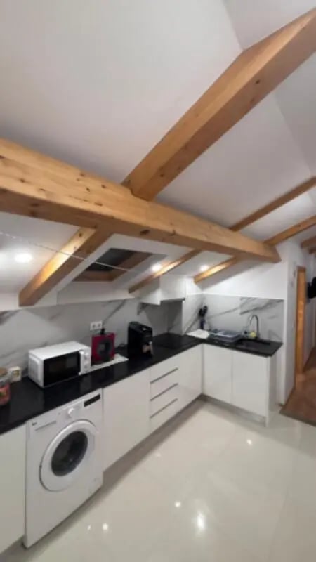 Modern kitchen with white cabinets microwave washing machine kitchen at Cozy Single Bedroom – Exclusively for IPVC Students, near Viana do Castelo Train Station in Viana Do Castelo Student Accommodation
