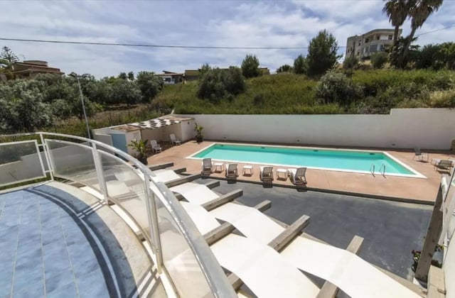 Pool with lounge chairs and buildings exterior at Comfy Apartment close to the beach in Agrigento Student Accommodation