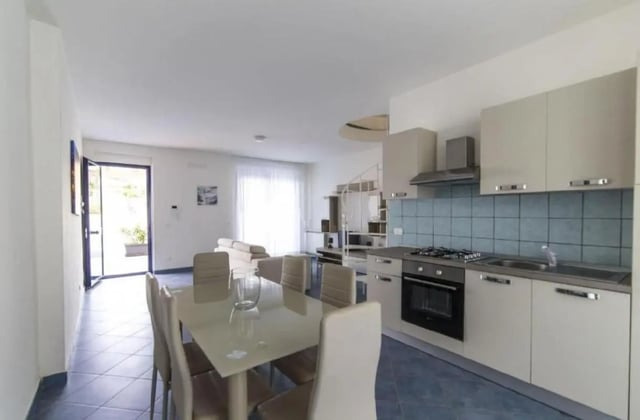 Dining table chairs kitchen counter with stove sink kitchen. at Comfy Apartment close to the beach in Agrigento Student Accommodation