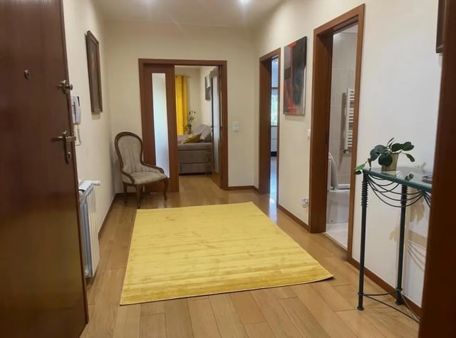 Hallway with yellow rug chair and doorways Interior at Exclusive 2 Bedroom Apartment with a balcony close to Minho University in Guimaraes Student Accommodation