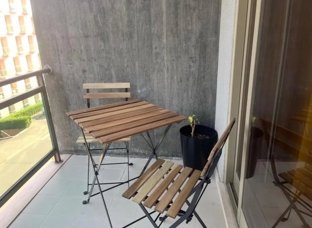 Balcony with wooden table chairs and plant exterior at Exclusive 2 Bedroom Apartment with a balcony close to Minho University in Guimaraes Student Accommodation