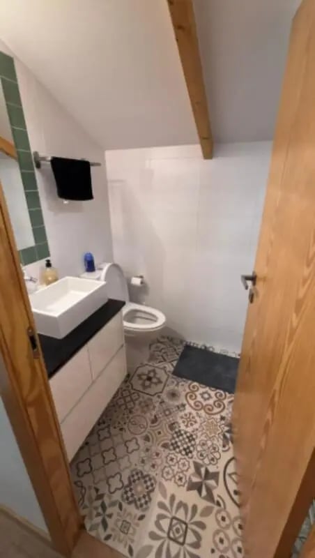 Sink toilet tiled floor and wooden door bathroom at Cozy Single Bedroom – Exclusively for IPVC Students, near Viana do Castelo Train Station in Viana Do Castelo Student Accommodation