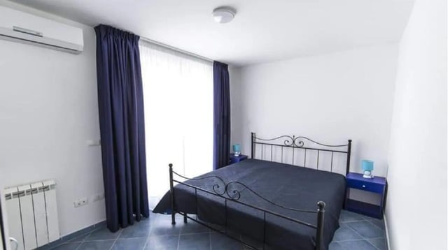 Metal frame bed dark bedding blue nightstands bedroom at Comfy Apartment close to the beach in Agrigento Student Accommodation