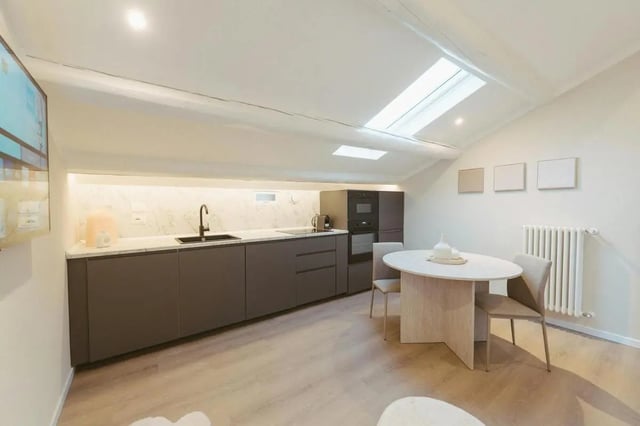 Modern kitchen with dining table and chairs kitchen at Charming 1-bedroom apartment near Pescara Centrale in Pescara Student Accommodation