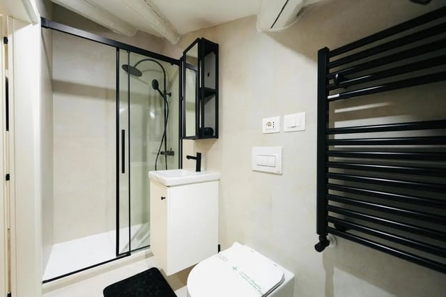Modern bathroom with shower sink toilet towel rail bathroom at Elegant 1-bedroom apartment near Pescara Centrale in Pescara Student Accommodation