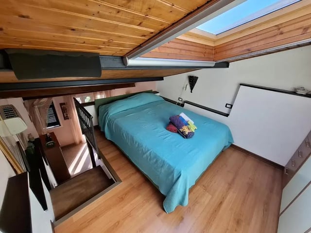 Bed with towels and skylight bedroom at Apartment with Terrace in Imperia in Imperia Student Accommodation