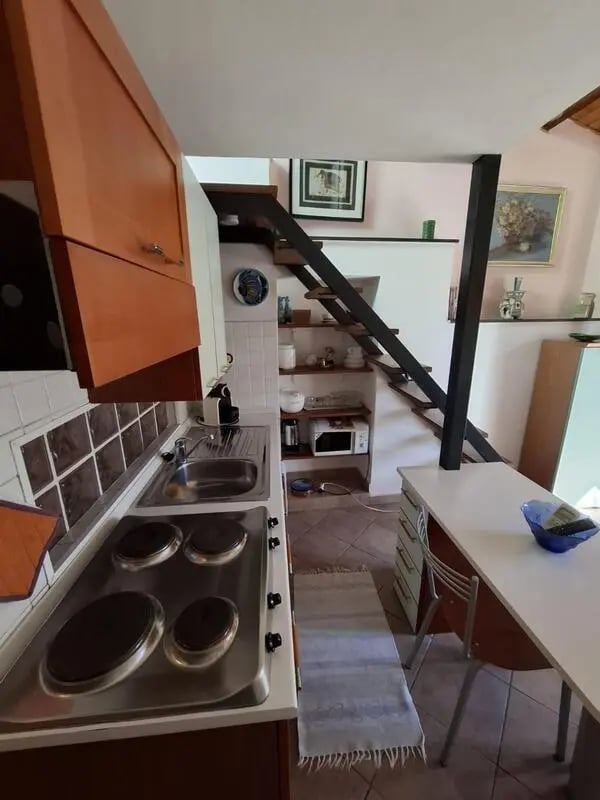 Compact kitchen with stove sink cabinets and stairs kitchen at Apartment with Terrace in Imperia in Imperia Student Accommodation