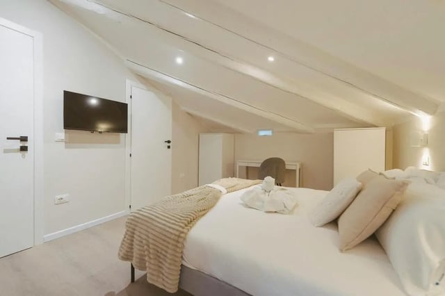 Bed with pillows and blanket white wardrobe bedroom. at Elegant 1-bedroom apartment near Pescara Centrale in Pescara Student Accommodation