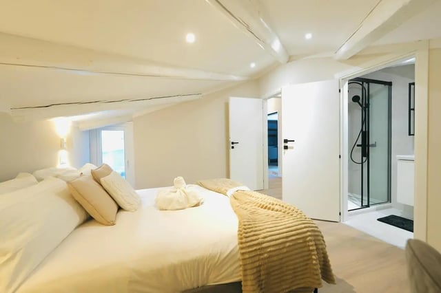 Bed with pillows throws opening to shower bedroom at Elegant 1-bedroom apartment near Pescara Centrale in Pescara Student Accommodation