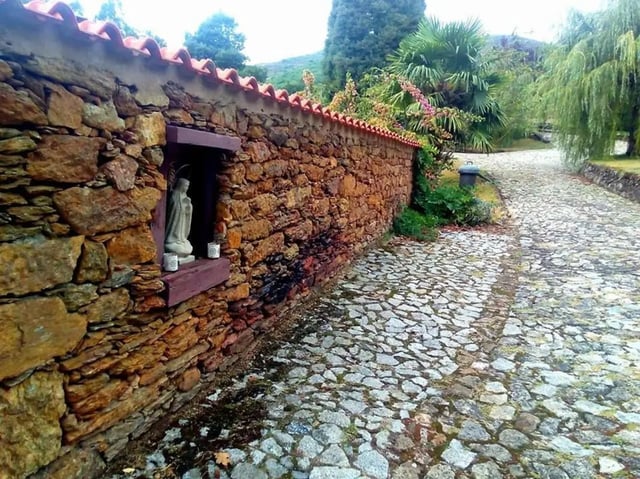 Stone wall niche statue cobblestone path exterior at Charming and serene country house in Sopo, Vila Nova de Cerveira in Viana Do Castelo Student Accommodation