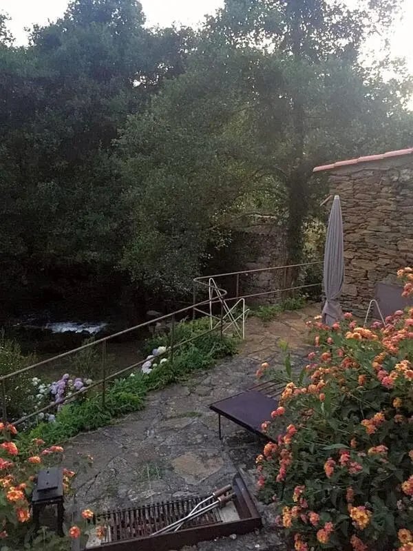 Grill patio furniture and river exterior at Charming and serene country house in Sopo, Vila Nova de Cerveira in Viana Do Castelo Student Accommodation