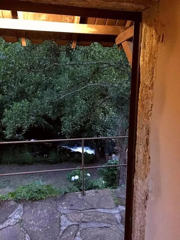Stone patio overlooks river and trees exterior at Charming and serene country house in Sopo, Vila Nova de Cerveira in Viana Do Castelo Student Accommodation