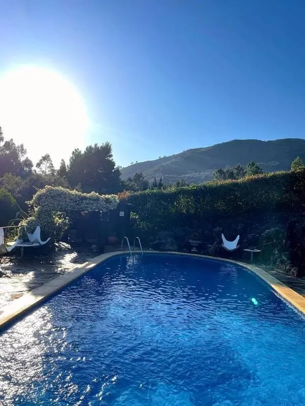 Pool with lounge chairs and lush greenery exterior at Charming and serene country house in Sopo, Vila Nova de Cerveira in Viana Do Castelo Student Accommodation