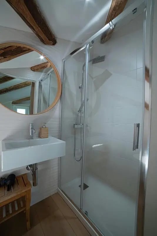 Sink shower wooden beams round mirror bathroom at Inviting 1-bedroom apartment near Pescara Centrale in Pescara Student Accommodation