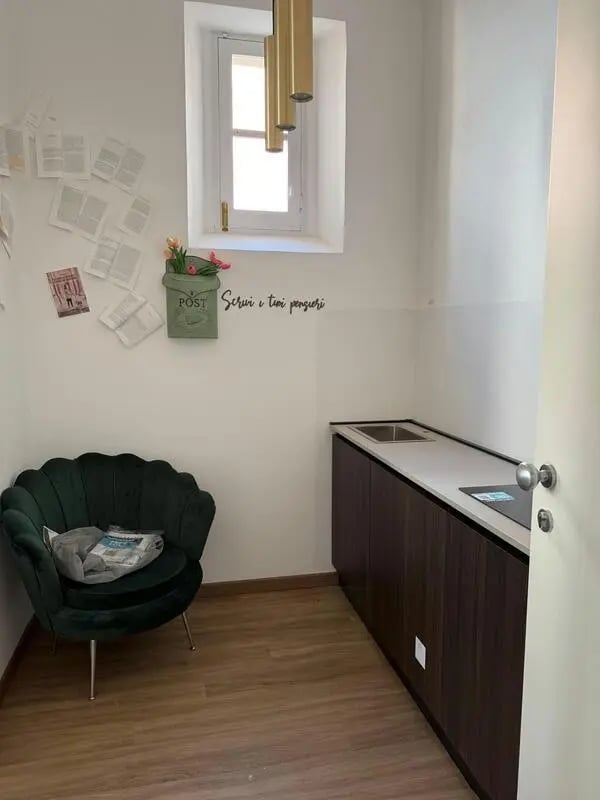 Green armchair and dark wood kitchen counter Kitchen at 1-Bedroom apartment near the Pescara Centrale in Pescara Student Accommodation