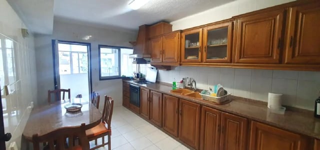 Wooden cabinets table chairs and sink kitchen at Double Bedroom close to Minho University 3 in Guimaraes Student Accommodation