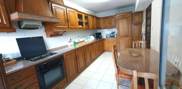 Wooden cabinets gas stove dining table kitchen. at Double Bedroom close to Minho University 3 in Guimaraes Student Accommodation