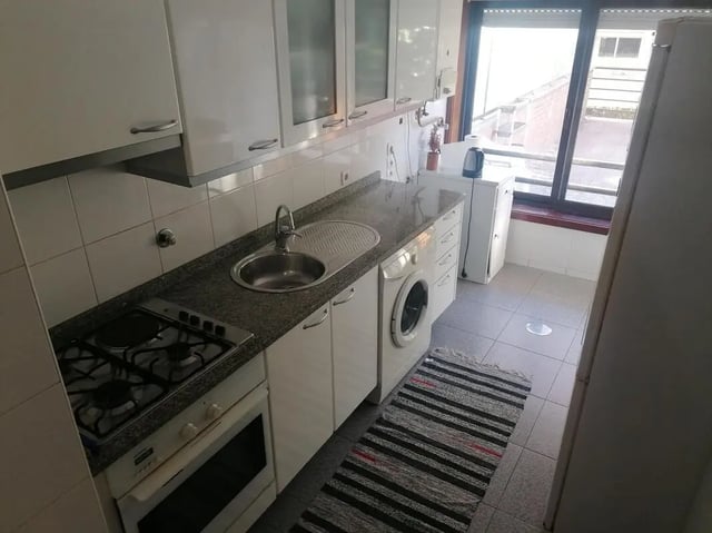 Stove sink washing machine rug kitchen at Cozy Single Bedroom close to Lavandeira Park in Vila Nova De Gaia Student Accommodation