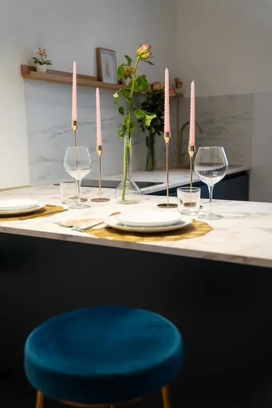 Candles wine glasses and plates on counter kitchen at Welcoming 1-bedroom flat near Pescara Centrale in Pescara Student Accommodation