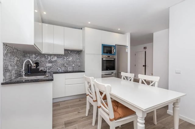 White table chairs oven sink kitchen area at Neat 2-bedroom flat in Olhão in Faro Student Accommodation