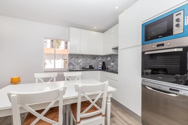 White table chairs oven microwave kitchen at Neat 2-bedroom flat in Olhão in Faro Student Accommodation