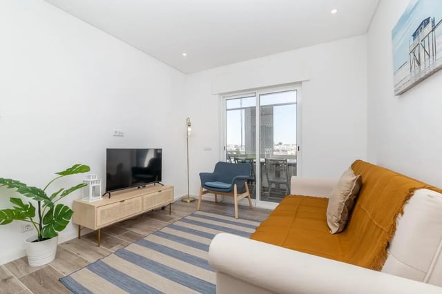 Sofa chair TV plant console living room at Neat 2-bedroom flat in Olhão in Faro Student Accommodation