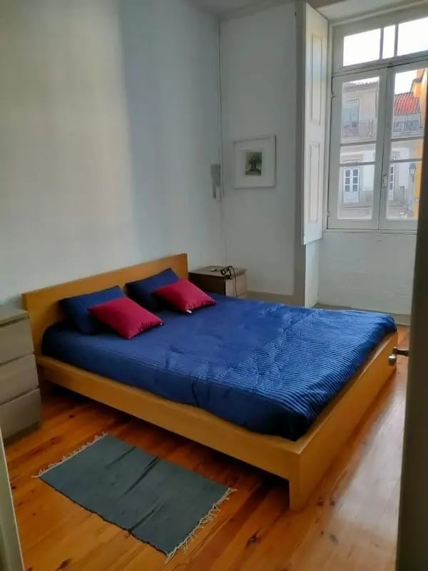 Blue bed with red pillows rug bedroom at Nice double bedroom in Ponte de Lima in Viana Do Castelo Student Accommodation