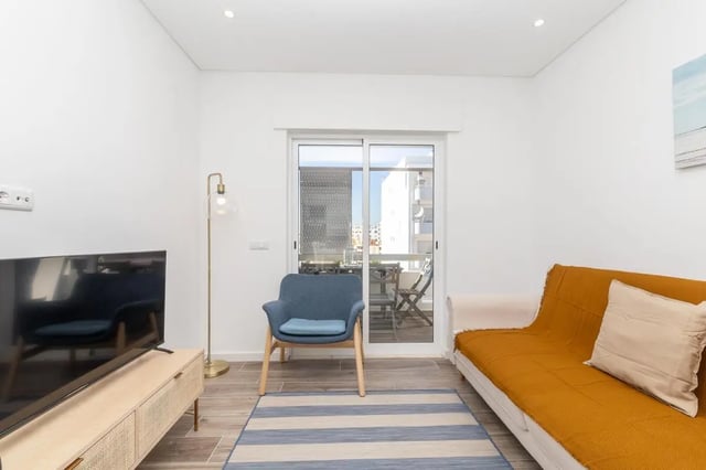 Sofa armchair rug TV stand living room at Neat 2-bedroom flat in Olhão in Faro Student Accommodation