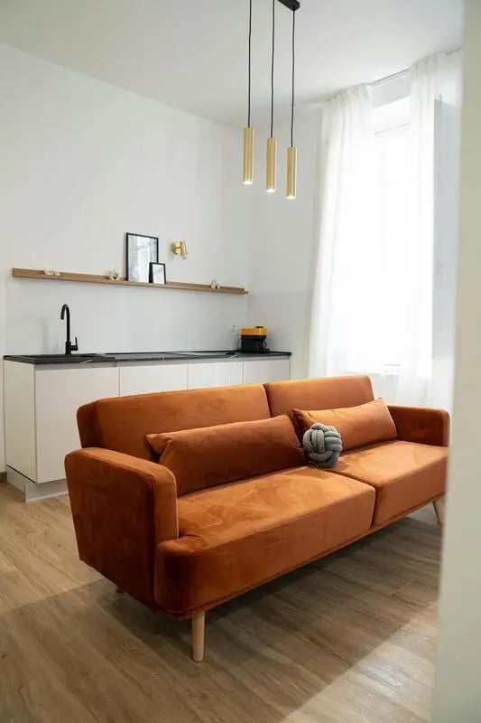 Orange sofa kitchen counter and sink Living room at Excellent 1-bedroom apartment near Pescara Centrale in Pescara Student Accommodation