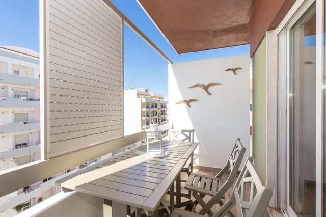 Balcony with table chairs and bird decor exterior at Neat 2-bedroom flat in Olhão in Faro Student Accommodation